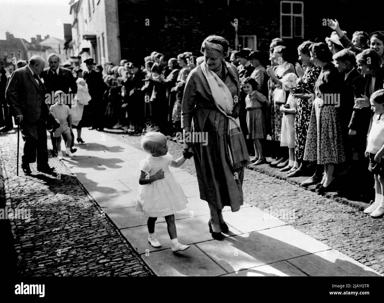 Mr. Churchill's Eighth Grandchild Is Christened: Mrs. Churchill arrives at the Church at Westerham holding the hand of Emma Soames her granddaughter. At the church yesterday Mr. Churchill's eighth grandchild the son of Mrs. Christopher Soames was named Jeremy Bernard. August 18, 1952. (Photo by Daily Mail Contract Picture). Stock Photo