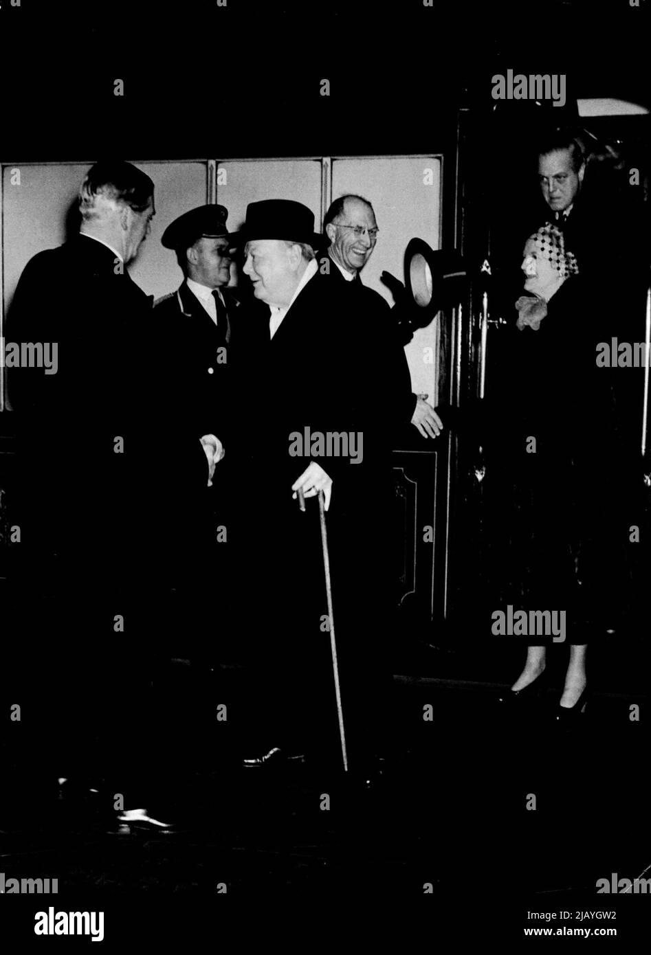 Mr. Churchill Returns From U.S.A.: Mr. Winston Churchill being greeted on arrival at Waterloo Station by Mr. Anthony Eden, Foreign Secretary, today. Also in the picture are Mrs. Churchill and (in the door) Mr. Randolph Churchill, the Premier's son. Mr. Churchill will be confronted by many problems on returning to his desk - not the least of which is the situation in the middle east. January 28, 1952. (Photo by Paul Popper, Paul Popper Ltd.). Stock Photo