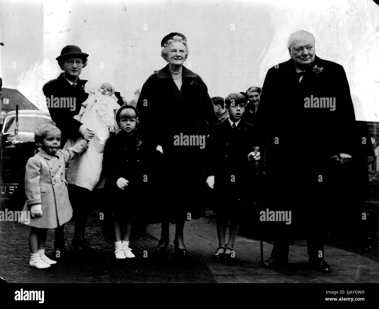 Sir Winston Takes His Grandson's Hand : Sir Winston and Lady Churchill arriving at Westerham Parish Church with the four children of Mr. and Mrs. Soames. The Prime Minister is holding the hand of Nicholas (who will be seven in February). Lady Churchill has the hand of Emma. On left are Jeremy, 2½, and Charlotte Clementine, held by a nurse. Sir Winston and Lady Churchill were present at the christening in Westerham (Kent) Parish Church to-day (Saturday) of their newest granddaughter four-months-old Charlotte Clementine Soames. November 06, 1954. (Photo by Reuterphoto). Stock Photo