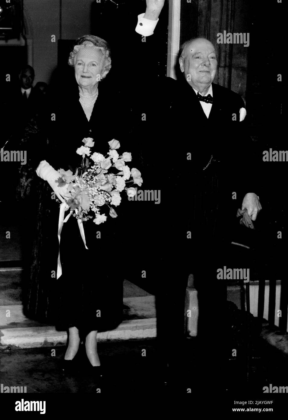 And The Crowds Cheered and Cheered : Back at No. 10 Downing Street after the Westminster Hall ceremony, Sir Winston Churchill full of emotion, acknowledges the crowds cheers. Smiling happily at his side is Lady Churchill. November 30, 1954. (Photo by Evening Standard Picture). Stock Photo