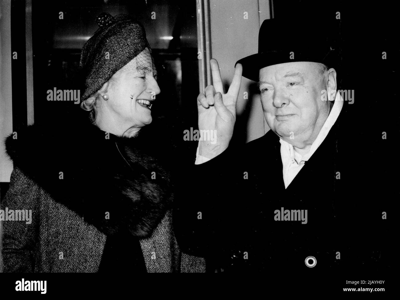 Victory In Sight? Winston Churchill's 'victory' sign is well to the fore as he leaves Padddington station, London, to-day (Wednesday) for Cardiff where he will make an election address to a huge meeting at the Ninian park football ground. With him is Mrs. Churchill. After speaking at Cardiff, Mr. Churchill will travel to Devonport to speak on behalf of his son, Randolph. February 08, 1950. (Photo by Reuterphoto). Stock Photo