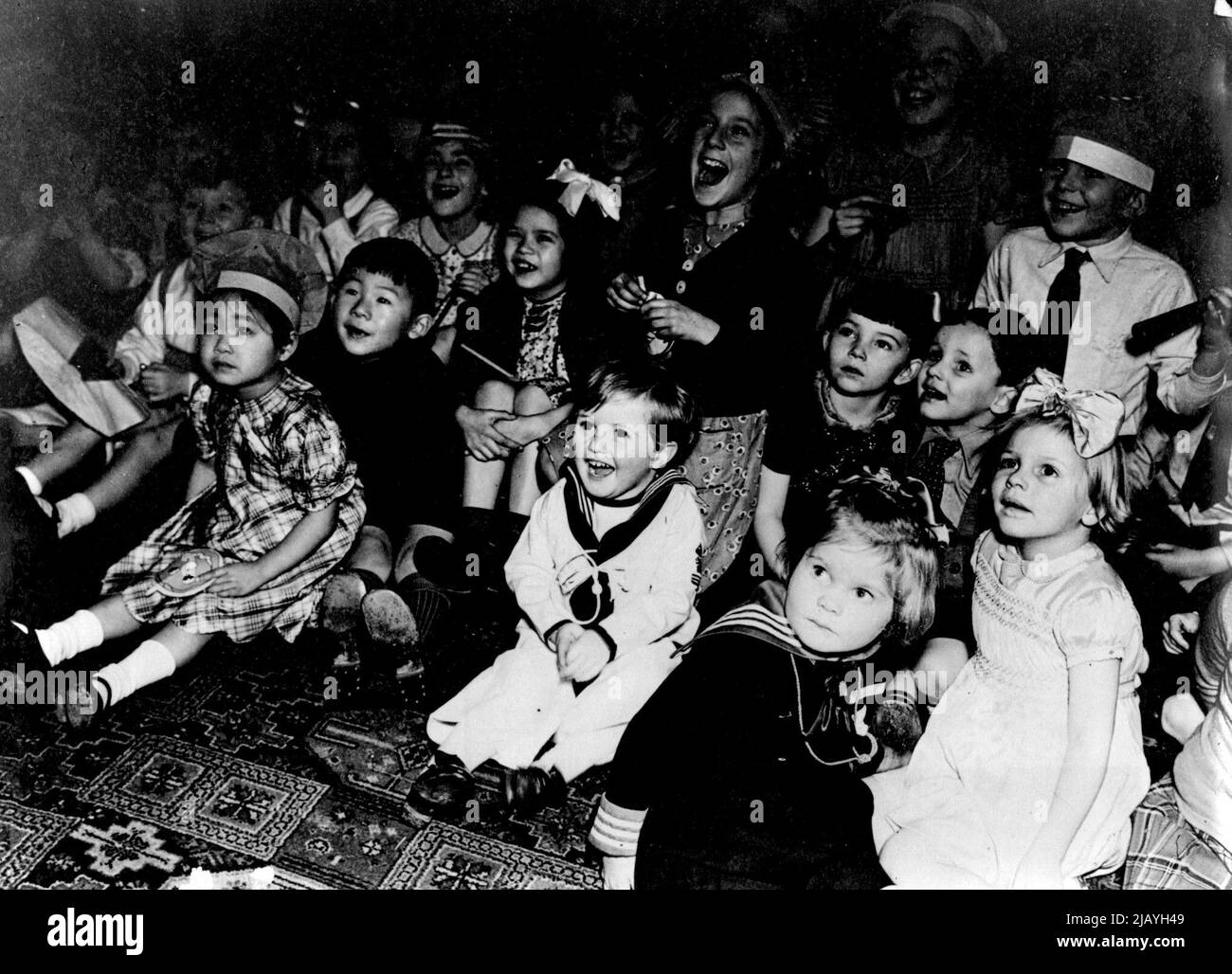 Mrs. A.V. Alexander Entertains United Nations Children: Happy Like his grandfather in the centre front is Master Winston Churchill, son of the Premier, Laughing at the Punch and Judy show with other Allied Children. Mrs. A.V. Alexander, Wife of the First Sea Lord of the Admiralty recently entertained children of Sixteen Allied Nations to a tea party at Admiralty House. The rooms were gay with decorations made of ear salvage. Comjuring tricks and the Punch and Judy were the most popular events with the children. Nearly 150 children of 16 Allied nations were present.  December 01, 1943. (Photo b Stock Photo