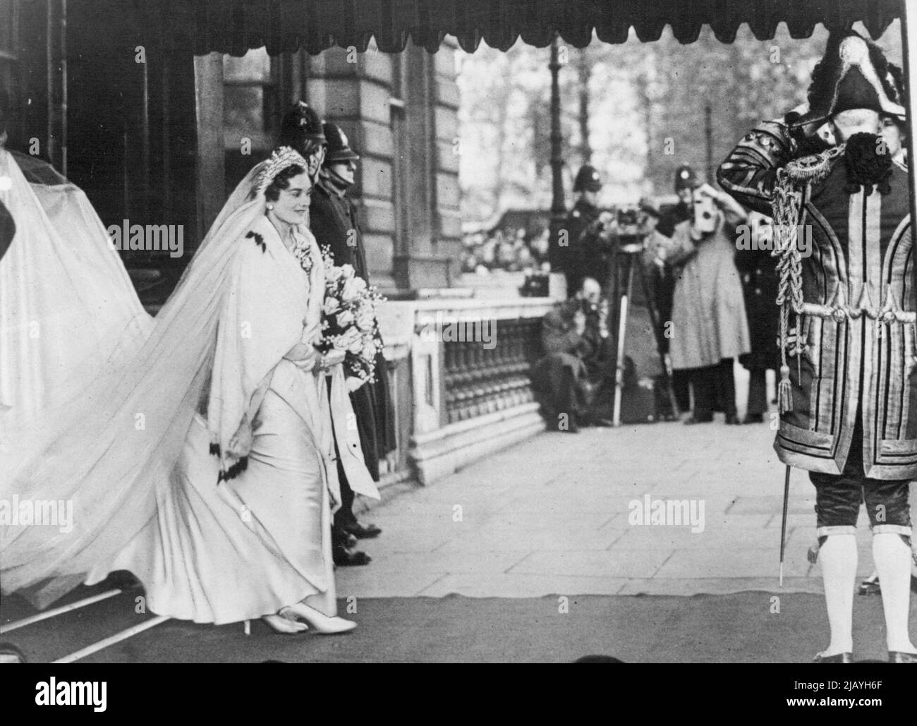 The Royal Wedding - Crowds cheer Duke's Bride -- The wedding of H.R.H. the Duke of Gloucester, third son of the King and Queen, and Lady Alice Montagu-Douglas-Scott, sister of the Duke of Buccleuch, took place in the private Chapel in Buckingham Palace, London, on Nov. 6th. Although the ceremony was private and simple owing to the recent death of the Bride's father, crowds lined the route to the palace to give the happy couple area Royal welcome. The Bride leaving her house No.2 Grosvenor Place, for Buckingham Palace. November 25, 1935. (Photo by Sport & General Press Agency Ltd.). Stock Photo