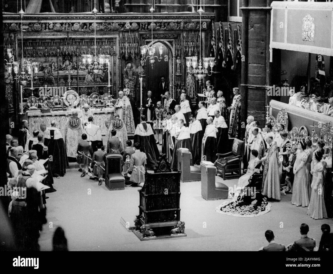 The Coronation of King George VI -- Scenes inside Westminster Abbey during the actual Coronation ceremony of King George VI, 12th May 1937. The King George - bareheaded - is seen kneeling before the Archbishop of Canterbury at the foot of the high Altar. Queen Elizabeth ***** the Queen Mother - is seen seated on right ***** stands the historic Coronation. May 12, 1937. (Photo by Sport & General Press Association Limited). Stock Photo