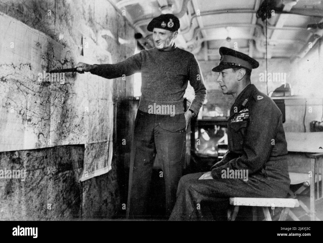 British Newspaper Pool Picture -- H.M. The King at the front. The King, in the map lorry at Field Marshal Montgomery's H.Q. hears the field Marshal explain the Holland campaign. December 17, 1944. (Photo by Sport & General Press Agency, Limited). Stock Photo