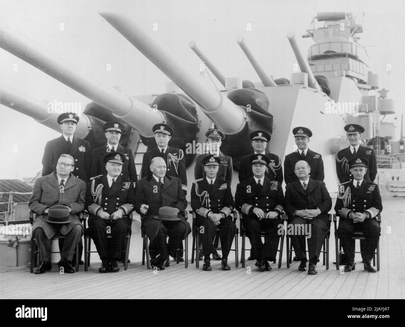 The King Aboard Us Warship: Front row l to r: Minister John W. Kenney (Chief of Mission for Economic Co-operation): First Sea Lord, Admiral of the Fleet Lord Fraser; US Ambassador Lewis Douglas; HM the King; Admiral Richard L. Conolly; First Lord of the Admiralty Viscount Hall; Admiral Algernon Willis, C in C Portsmouth. Standing l to r: Capt. E. R. McLean, captain of the Columbus; Rear Admiral Belger, U.S. Joint Planning Staff; Rear Admiral D.S. Cornwell, US Naval Attache, London; Major General A.M. Harper, Joint Planning Staff; Rear Admiral G.R. Henderson, Chief of Staff to Admiral Conolly; Stock Photo