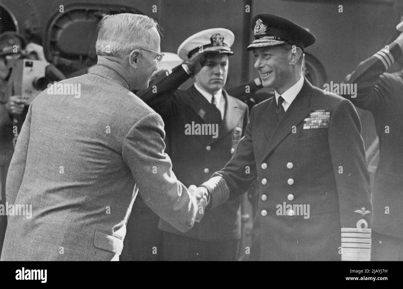 President Truman received by The King in Plymouth Sound - His Majesty shakes hands with President Truman on bearding the cruiser Augusta. President Truman, who flew to England after the Potsdam Conference, was received by the King on board the battle-cruiser H.M.S. Renown in Plymouth Sound, before he sailed to the United States in the American cruiser Augusta. During his visit to England the President saw the Barbican Stone and Mayflower Steps, where the Pilgrim Fathers set sail for New England in 1620. August 02, 1945. Stock Photo