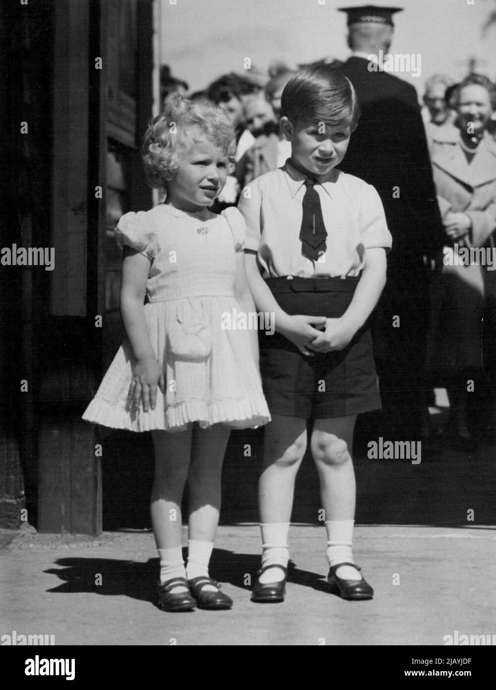 The Seasoned Travelers -- Two very composed small children arrive at Ballater Station, today. They are Prince Charles and Princess Anne - their Scottish holiday ended - who motored from Balmoral to the station to catch the overnight train, London-bound. Prince Charles, short-sleeved and sporting a large tie-pin, stands with fingers lightly clasped in front beside his sister Anne who wears a short-sleeved summer dress. June 01, 1964. (Photo by Daily Express). Stock Photo