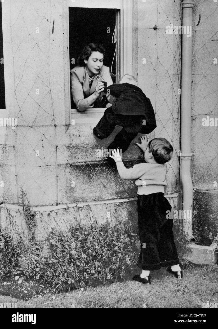 Help For Princess Anne Princess Anne is assisted by the Queen and Prince Charles to climb in through one of the windows of Balmoral Castle. Prince Charles having climbed up once, jumped down again to help his little sister in her efforts to copy him. May 1, 1953. (Photo by Fox Photos). Stock Photo