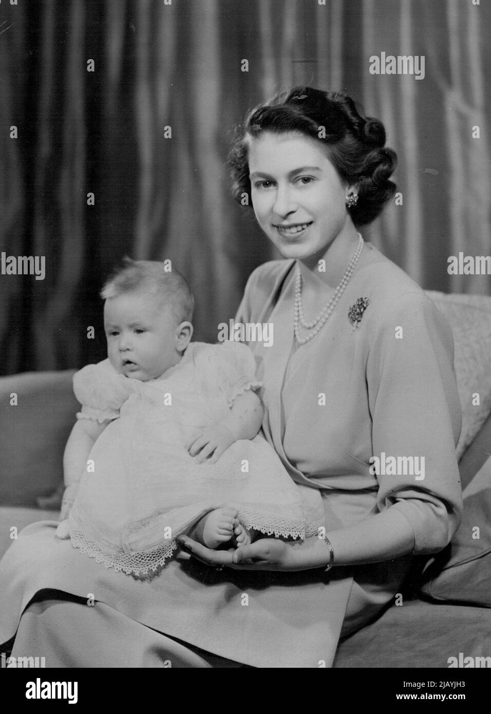 H.R.H. Princess Elizabeth And Prince Charles : Taken by Royal Command, picture shows H.R.H. Princess Elizabeth with Prince Charles in her private sitting room at room at Buckingham Palace. - Princess Elizabeth is dressed in dove-grey. Her Royal Highness will be 23 years of age on ***** April 1949. April 9, 1949. (Photo by Baron, Camera Press). Stock Photo