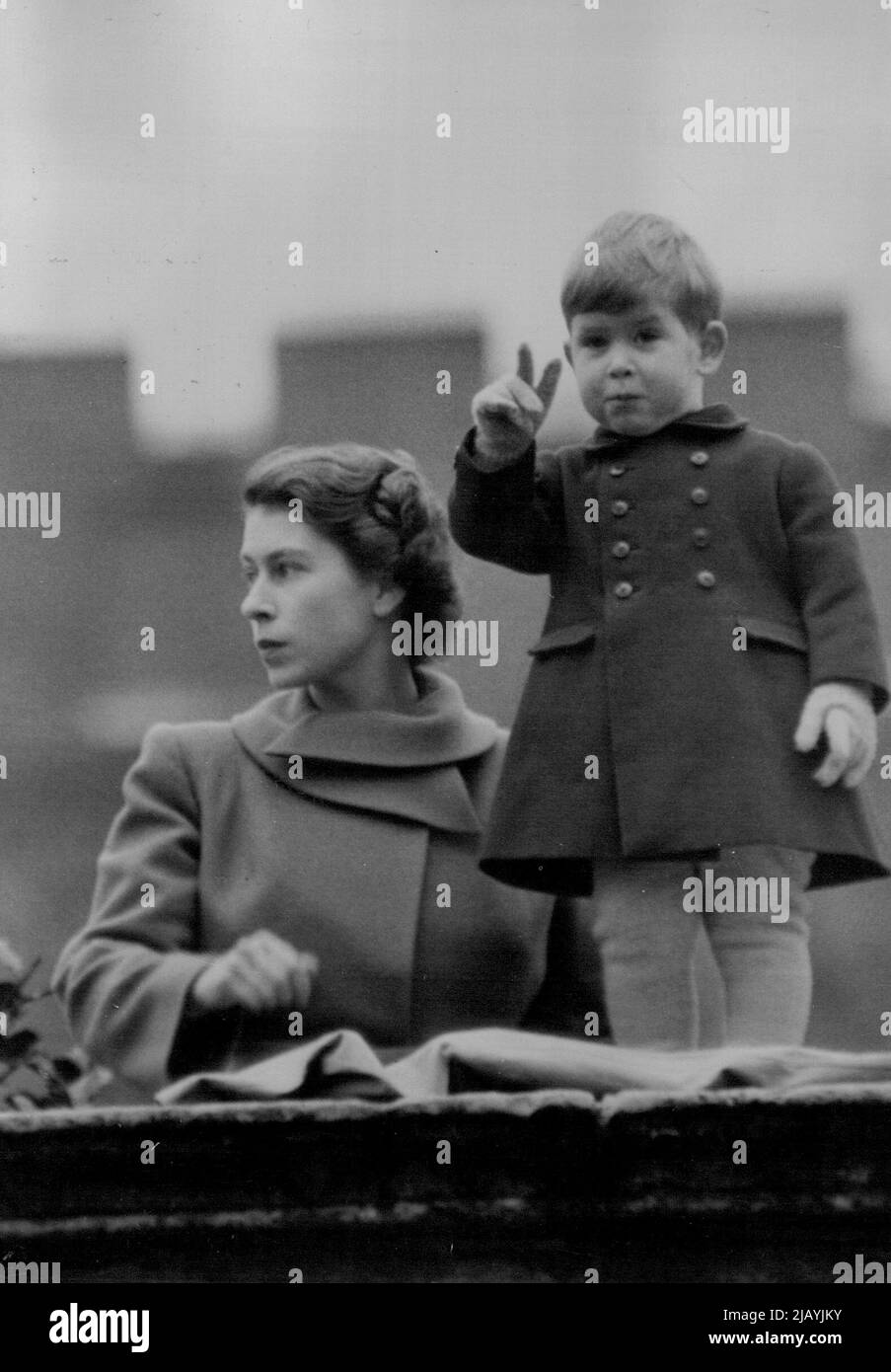 Prince Charles - With Mother - Watches Queen Juliana Drive To Guildhall : Princess Elizabeth holds her two-year-old son, Prince Charles, as they watch the procession from a wall at Clarence House. Queen Juliana and Prince Bernhard of the Netherlands, accompanied by a Sovereign's Escort of the Household Cavalry, were to-day driven from Buckingham Palace to Guildhall, where an address was presented by the Lord Mayor, Alderman Denys Lowson, and the Corporation of the City of London. At the Guildhall the Duke and Duchess of Gloucester met the Royal visitors, who were entertained by the Lord Mayor Stock Photo