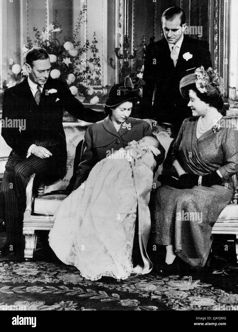 Royal Baby Christened At Buckingham Palace : First Picture of Princess Elizabeth With Son. The first picture of the baby Prince Charles - and the King since his illness - taken at Buckingham Palace. The King is seen seated at left with the Duke of Edinburgh (Standing) Princess Elizabeth (holding baby Prince Charles) and the Queen Elizabeth. All are admiring the young Prince. Prince Charles, baby son of Princess Elizabeth and the Duke of Edinburgh was christened at Buckingham Palace, the Archbishop of Canterbury Dr Geoffrey Fisher, officiating. The baby was named Charles Philip Arthur George an Stock Photo