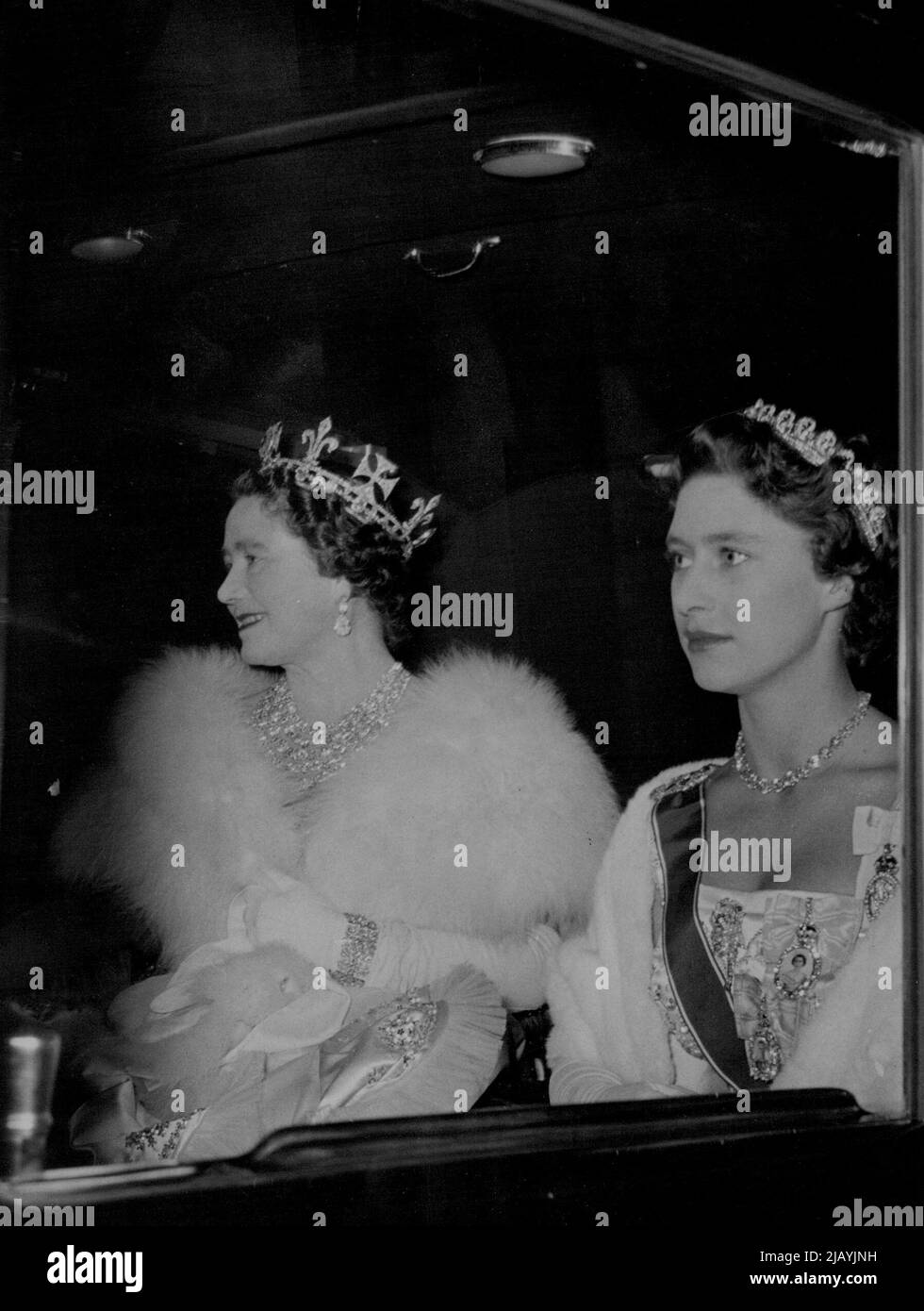 Queen Mother, Princess Margaret, Drive To Banquet For Portuguese President. A graciously smiling Queen Mother, a pensive Princess Margaret, drive in the state coach to the Buckingham Palace banquet. President Craveiro Lopes of Portugal arrived in London with his wife Tuesday on a State Visit, the first such form a Portuguese President for more than half a century. The Portuguese visitors were welcomed on disembarkation at Westminster Pier by Queen Elizabeth and other members of the British Royal Family. During the afternoon President and Madame Lopes went to Britain's historic Westminster Abbe Stock Photo