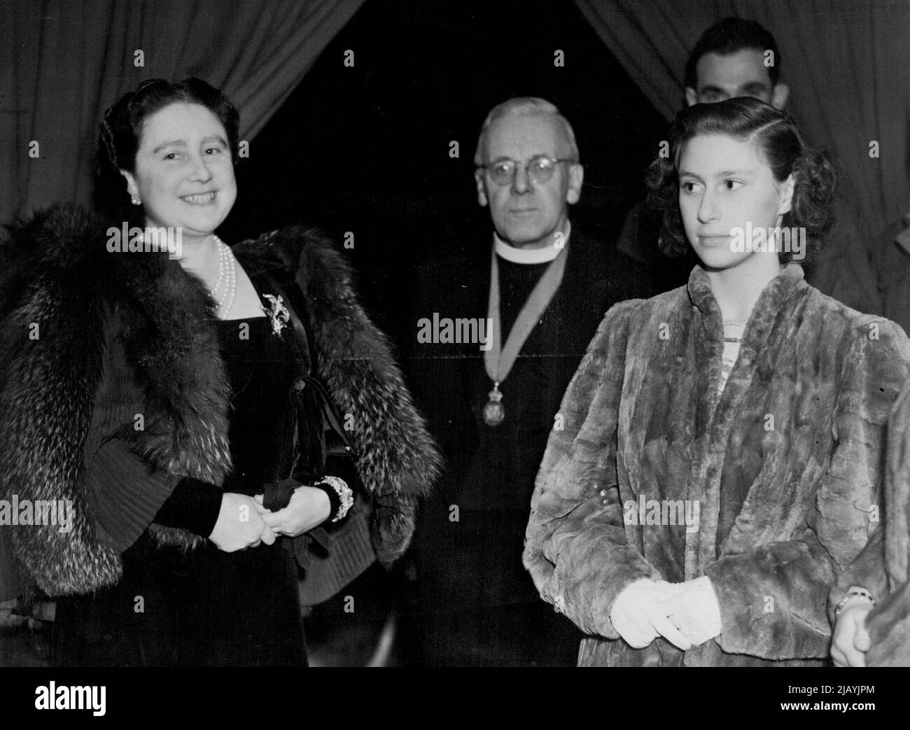 Her Majesty The Queen and Princess at Concert In Aid Of Toc H. -- The Queen, The Rev. 'Tubby' Clayton and Princess Margaret Rose in the Royal Box. A concert in aid of Toc H arranged by Dr. Malcolm Sargent at the Royal Albert Hall, was attended by The Queen and Princesses. January 07, 1946. (Photo by London News Agency Photos Ltd.) Stock Photo