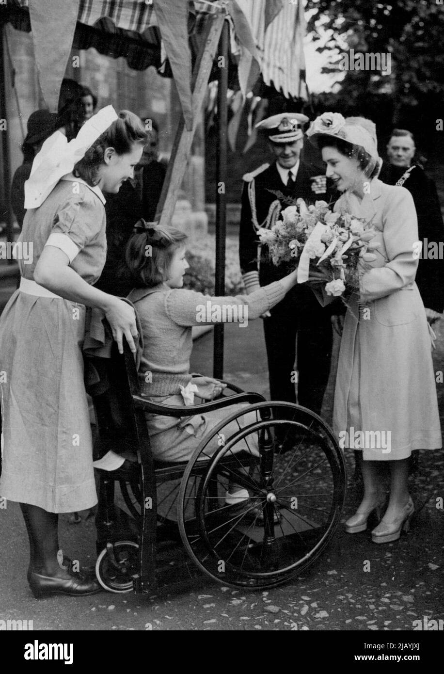 The 'Patron goes to Bath - Princess Margaret, wearing a charming spring hat and high platform shoes, receiving a bouquet from thirteen-year-old Joan Davidge, a patient at bath Orthopedic Hospital. Thousands lined the streets of Bath today to welcome Princess Margaret on her first visit to the city. A police cordon was broken at the Guildhall and hundreds rushed forward to her car. The Princess was there as patron of the Bath Assembly which closed today. May 01, 1948. Stock Photo