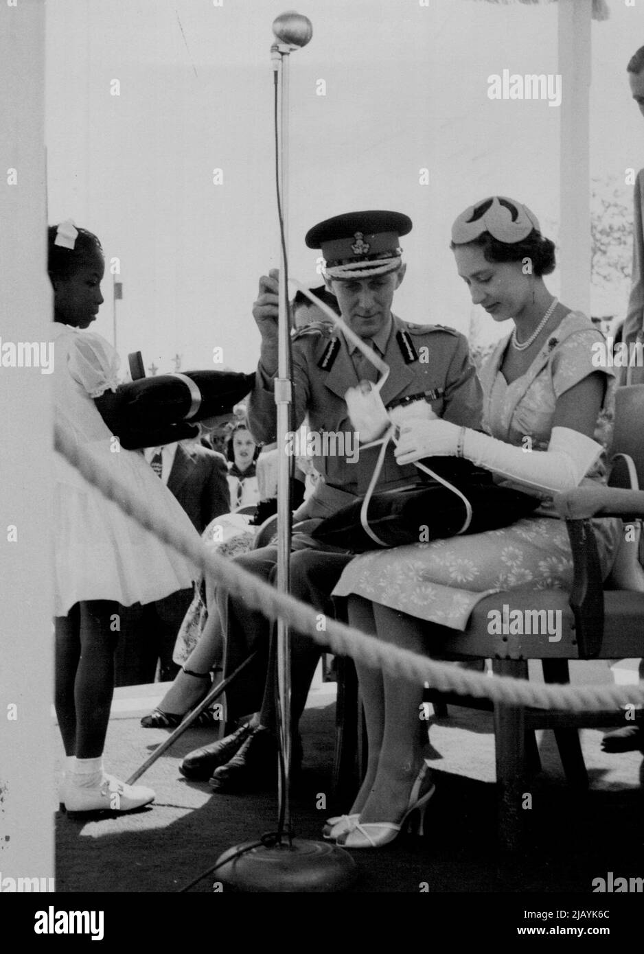 Assisted by the Earl of Ranfurly, Governor of the Bahamas, Princess Margaret opens a gift of a tortoiseshell vanity case. It was presented to her by two little girls on behalf of the people of the Bahamas at a youth rally held on Monday 28th February at Clifford Park, Nassau. February 03, 1955. (Photo by Daily Mirror). Stock Photo