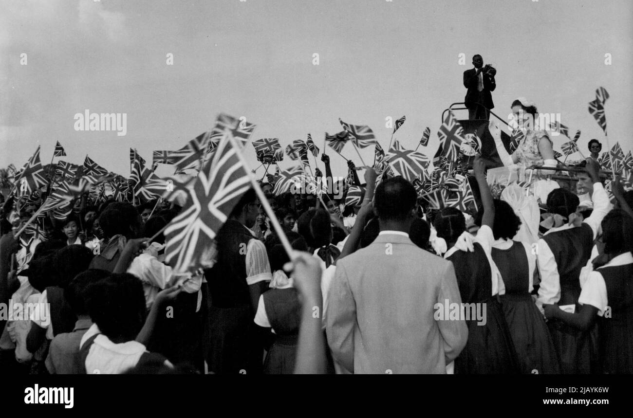 Cheers for Princess -- Flag-waving school children cheers as Princess Margaret drives past them in a land over at San Fernando, Trinidad, February 4. February 21, 1955. (Photo by Associated Press Photo). Stock Photo