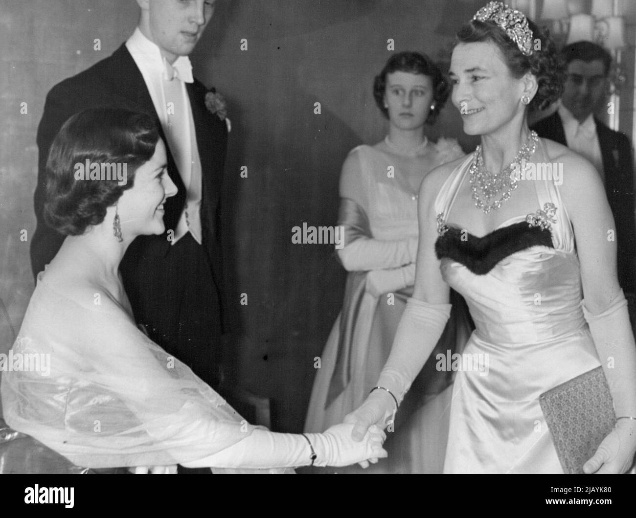 Duchess Attends Snow Ball -- Patricia Barry curtsies to the Duchess of Gloucester. The Duchess of Gloucester attended the Snow Ball in aid of the United Appeal for the Blind and the British Empire Society for the Blind, which was held at the Dorchester Hotel, London, last night. December 16, 1954. (Photo by Evening Standard Picture) Stock Photo