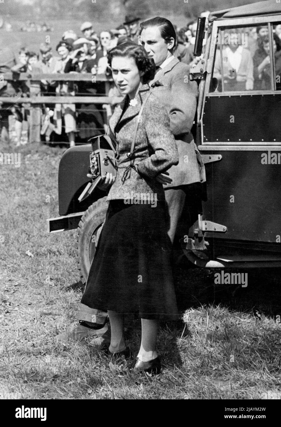 Princess Margaret At Badminton - H.R.H. Princess Margaret keenly interested as she stands with her camera ready at one of the jumps of the Cross Country course at Badminton yesterday. With the Princes is Mr. David Somerset, a cousin of the Duke of Beaufort. H.N. The Queen, Princess Margaret and other members of the Royal Family again attended the International Horse Trials at Badminton yesterday. At this, the second day of three-day event, the Royal visitors watched the Cross Country, Speed and Endurance tests in bright Spring sunshine. April 24, 1953. (Photo by Fox Photos). Stock Photo