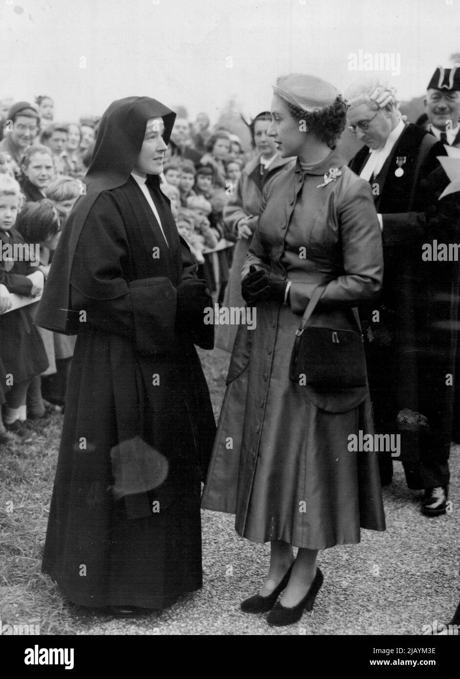 Absorbed in cover Princess Margaret and a Sister of Mercy in the midst of schoolchildren at Henle Thames, where to-day the Princes Planted the first tree of the new Avenue in the Fail Mile. Absorbed In Conversation, Princess Margaret and a Sister of Mercy talk in the midst of school children at Henley, Thames, where Princess Margaret planted the first tree in Fair Mile recently. October 16, 1953. (Photo by Daily Mail Contract Picture). Stock Photo