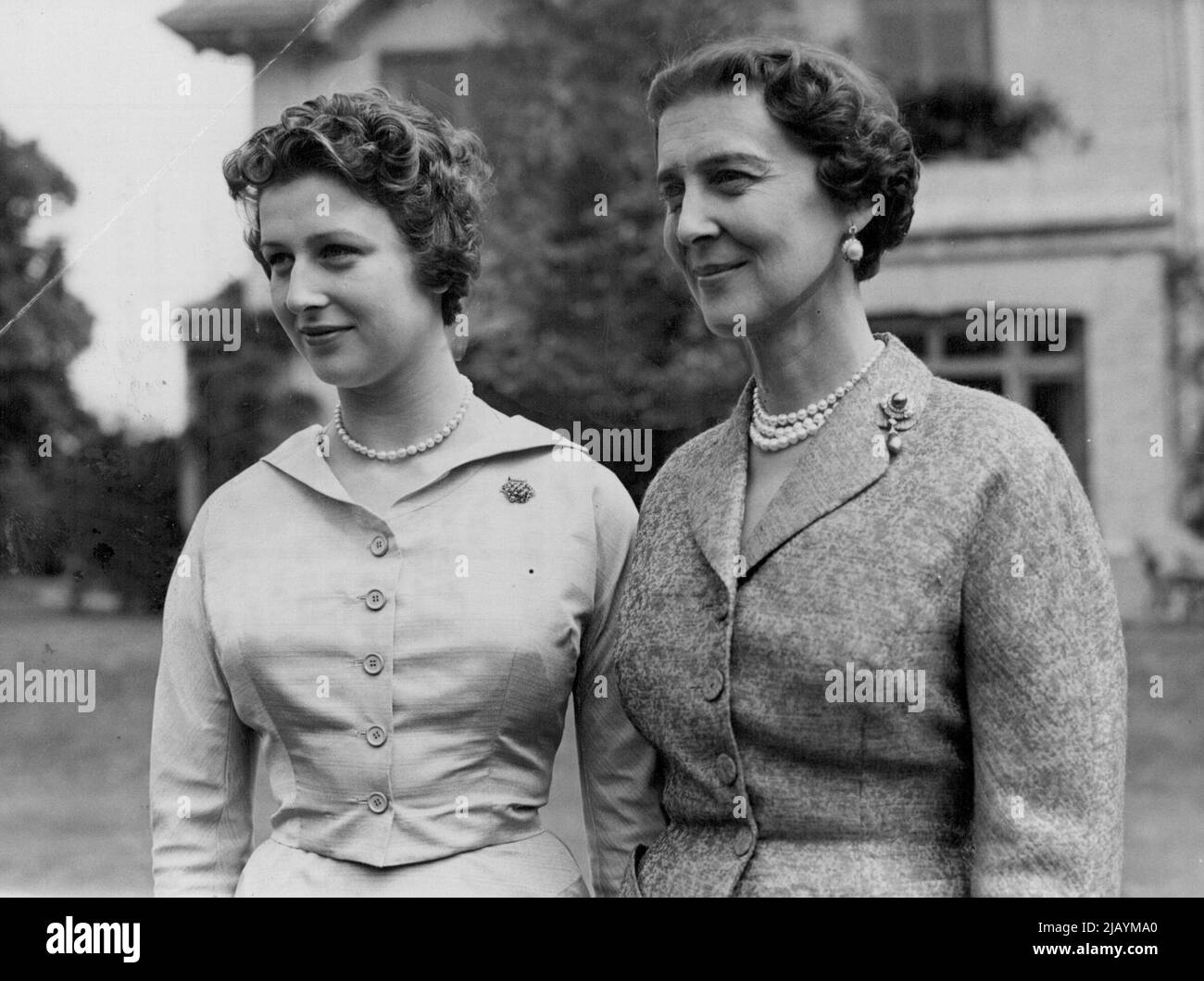 At Home to Photographers -- Princess Alexandra with her mother, The Duchess of Kent, in the grounds of the Buckinghamshire home today. Princess Alexandra, 17, daughter of The Duchess of Kent, was officially 'At Home' to photographers today. With her mother, the princess posed for a number of cameramen in the grounds of the coppins, in Iver, Buckinghamshire. The Princess made her debut in public life this summer and has carried out a number of social and official engagements, alone, of with her mother. July 09, 1954. (Photo by Paul Popper, Paul Popper Ltd.) Stock Photo