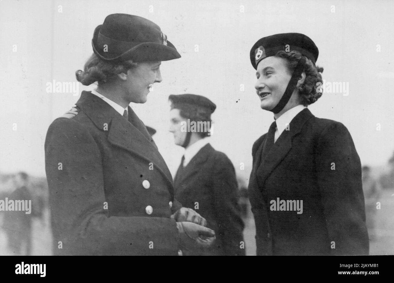 The Duchess of Kent Inspects 'Front Line' Wrens -- The Duchess of Kent talking to a smiling member of the W.R.N.S. wearing the badge of the Royal Marines. The Duchess of Kent made a tour of naval establishments at Dover, where members of the W.R.N.S. have been serving in various capacities, almost continuously throughout the air raids, bombing and shell-fire which the war brought to this 'front line' town. October 12, 1944. Stock Photo