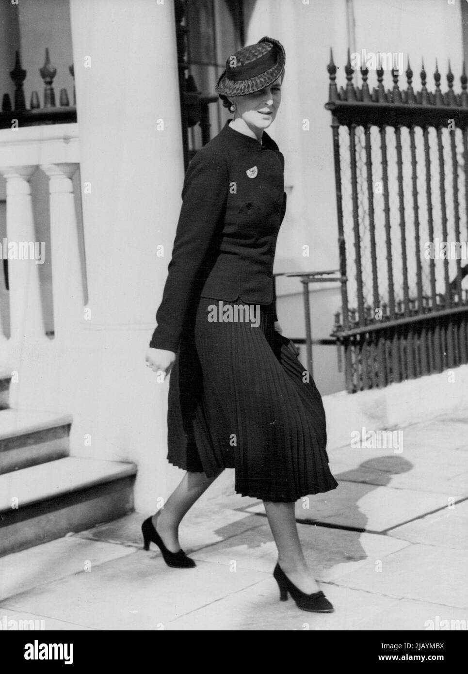 Duchess of Kent Pays Shopping Visit To London -- The Duchess of Kent, wearing a black straw hat and a pleated skirt, leaving her London home at 3, Belgrave Square, to continue her shopping expedition. The Duchess of Kant paid a brief visit to London for shopping and then returned to The Coppins , Iver, Buckinghamshire, to rejoin the Duke and the children. September 19, 1938. Stock Photo