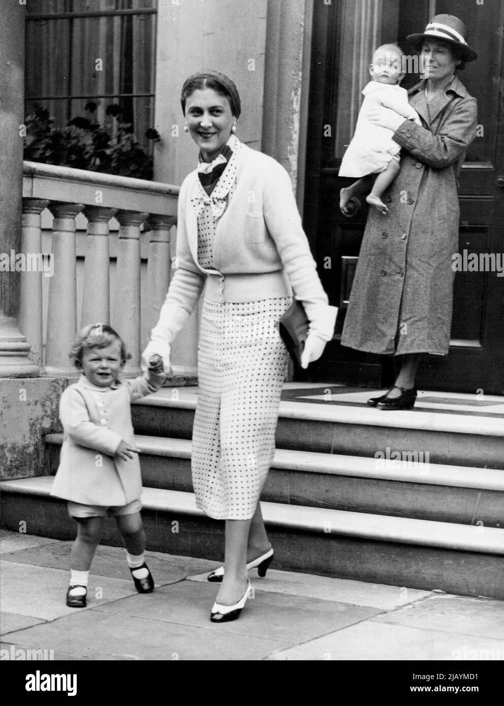 Royal Children Leave For Holiday -- The Duchess of Kent holding Prince Edward's arm, being followed by her baby daughter, Princess Alexandra, leaving Belgrave Square, London, this afternoon. The Duchess of Kent, accompanied by her children, left London this afternoon for a holiday at Sandwich. July 26, 1937. (Photo by Topical Press). Stock Photo