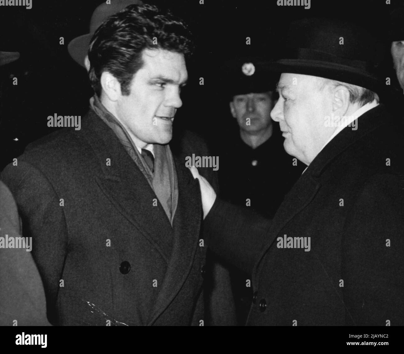 One Champ to Another -- Winston S. Churchill, leader of the British conservative party, gives a friendly pat on the shoulder to boxer Freddie Mills at Paddington station this morning Feb. 8. Freddie was among the people gathered to see Churchill off to Cardiff Churchill will address a mass meeting of 50,000 people at a Cradiff, Wales, football ground as part of his election campaign. February 27, 1950. (Photo by Associated Press Photo). Stock Photo