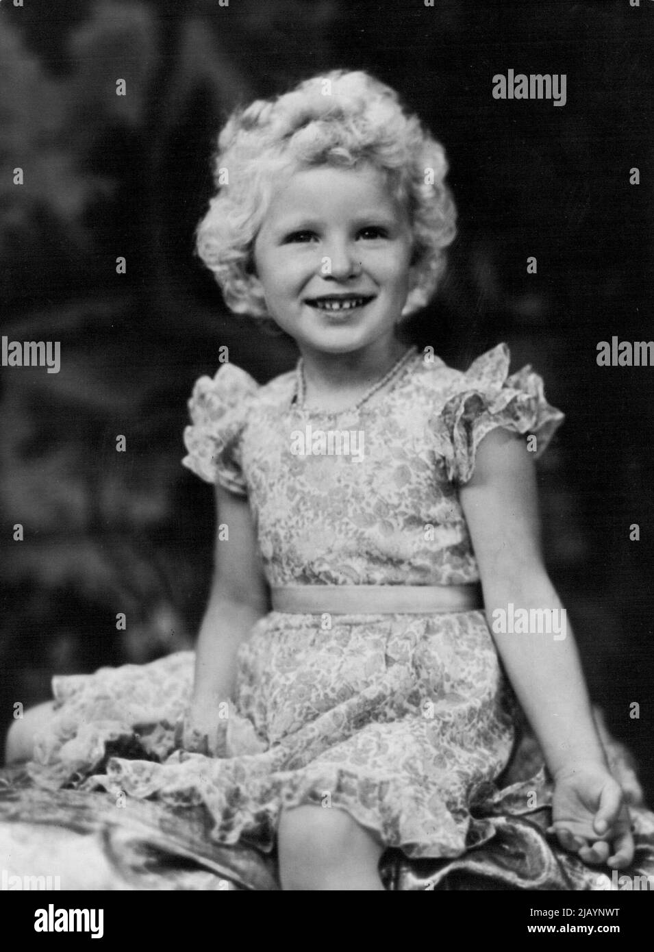 Picture of Princess Anne taken specially for the occasion of her fourth birthday by Marcus Adams. She is wearing a frock of figured voils over taffeta with a pink coral and pearl necklace. Princess Anne is four today - and this afternoon young guests joined the Princess and her brother, Prince Charles, at a birthday tea-party at Balmoral Castle. A special iced sponge-cake has been made by Mr. Ronald Aubrey, the Royal chef. The Royal Children today accompanied the Queen to a service in Craithie Church near Balmoral castle. It was the first time that Princess Anne had attended a service in the c Stock Photo