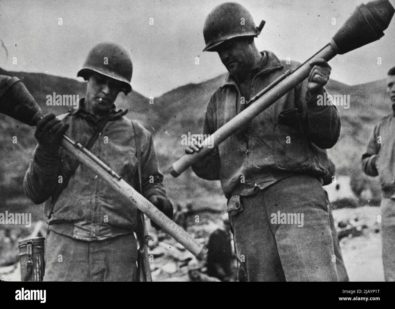 U.S. Soldiers Examine German Bazooka -- German, Bazooka, imitations of the American anti-tank guns, are examined by two U.S. soldiers after the weapons were captured during fighting on the outskirts of Cassino in Western Italy. The bazooka was developed in the United States as an infantryman's anti-tank weapon. March 20, 1944. Stock Photo