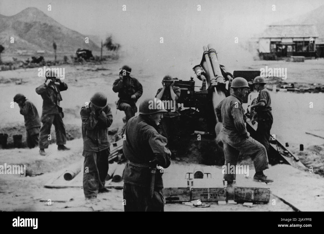 In Action In Korea: Men of a 155mm Howitzer crew hold their ears as their gun goes into action in the fight to push back the North Koreans. A front line picture from 'somewhere in Korea'. August 10, 1950. (Photo by Paul Popper Ltd.). Stock Photo
