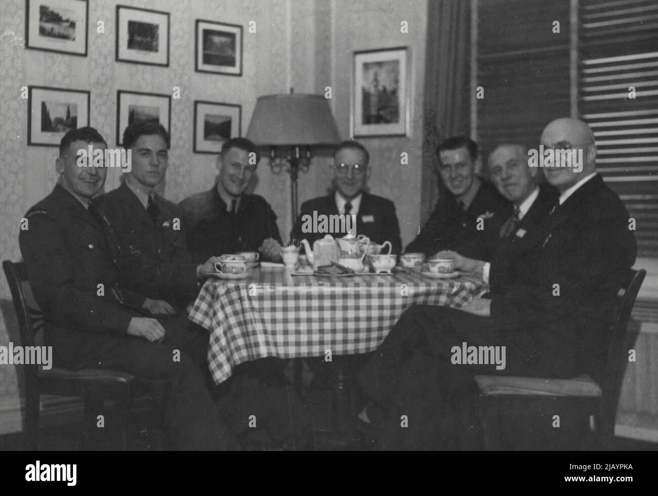Seated Left to Right -- P/O Ryan, John -- Invercargill, P/O Williams, Alex -- Waikato, Sgt. Goodrich, Ron. -- Melbourne, Hon. Drakeford -- Melbourne, Sgt. Larkin, Colin, Harden, N.S.W., Mr. H.P. Drakeford (Hon. Drakeford's Brother), Mr. E.H. Scott-Sponsor of Anzac Center from Dunedin. January 31, 1945. Stock Photo