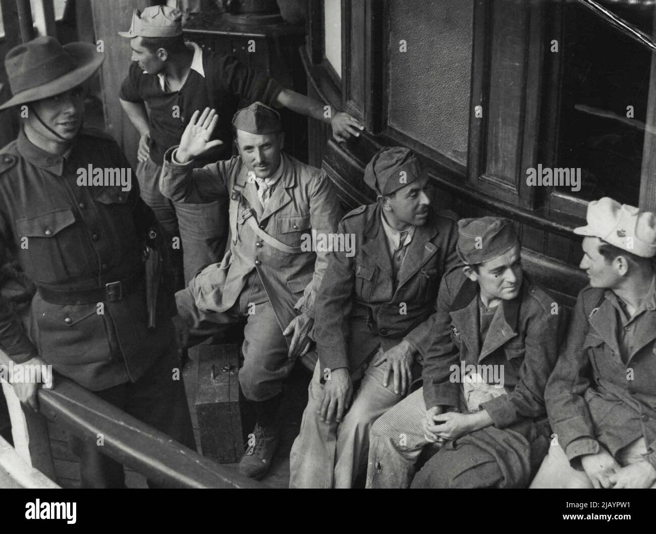 Fascist Salute In Sydney -- The Italian soldier on the left gives the salute to the camera as the Sydney ferry takes him ashore for internment. These are some of a big batch of Italian prisoners captured in North Africa and landed in Sydney today. May 26, 1941. Stock Photo