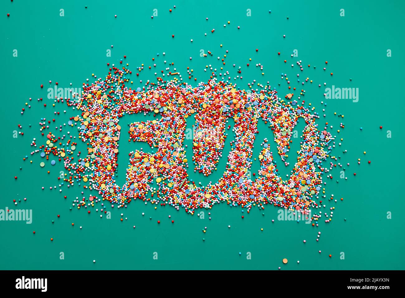Fun word written on colorful sweet sprinkles, green background Stock ...