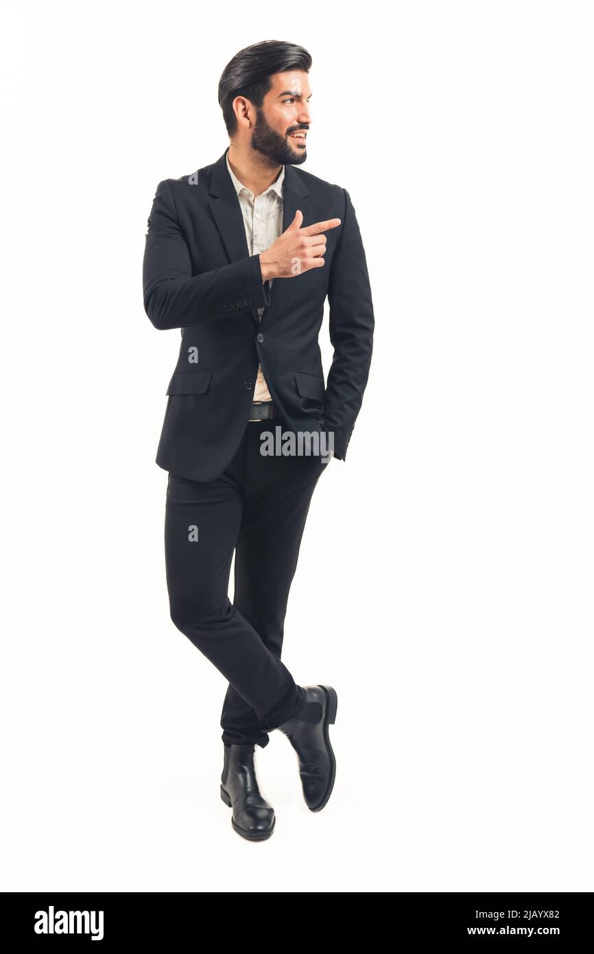 Attractive Latin biznessman stands cross-legged while showing to the side. High quality photo Stock Photo
