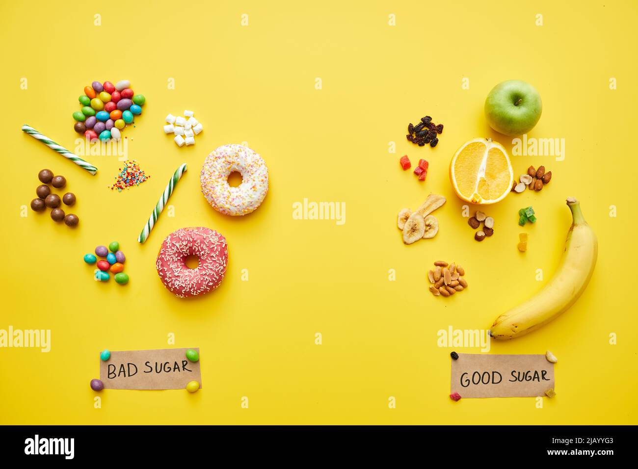 Good and bad sugars concept two handfuls of unhealthy candies and
