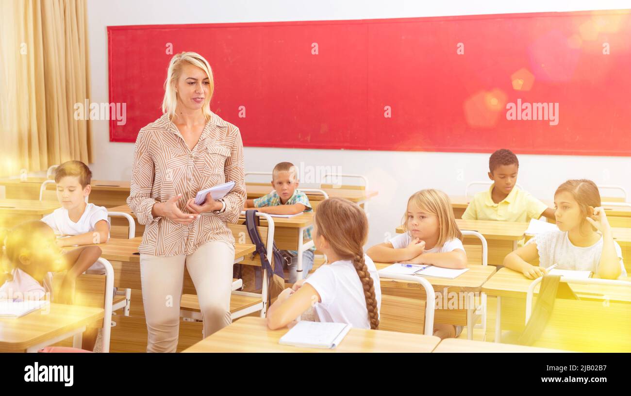 Teacher communicates freely with students in classroom at elementary ...
