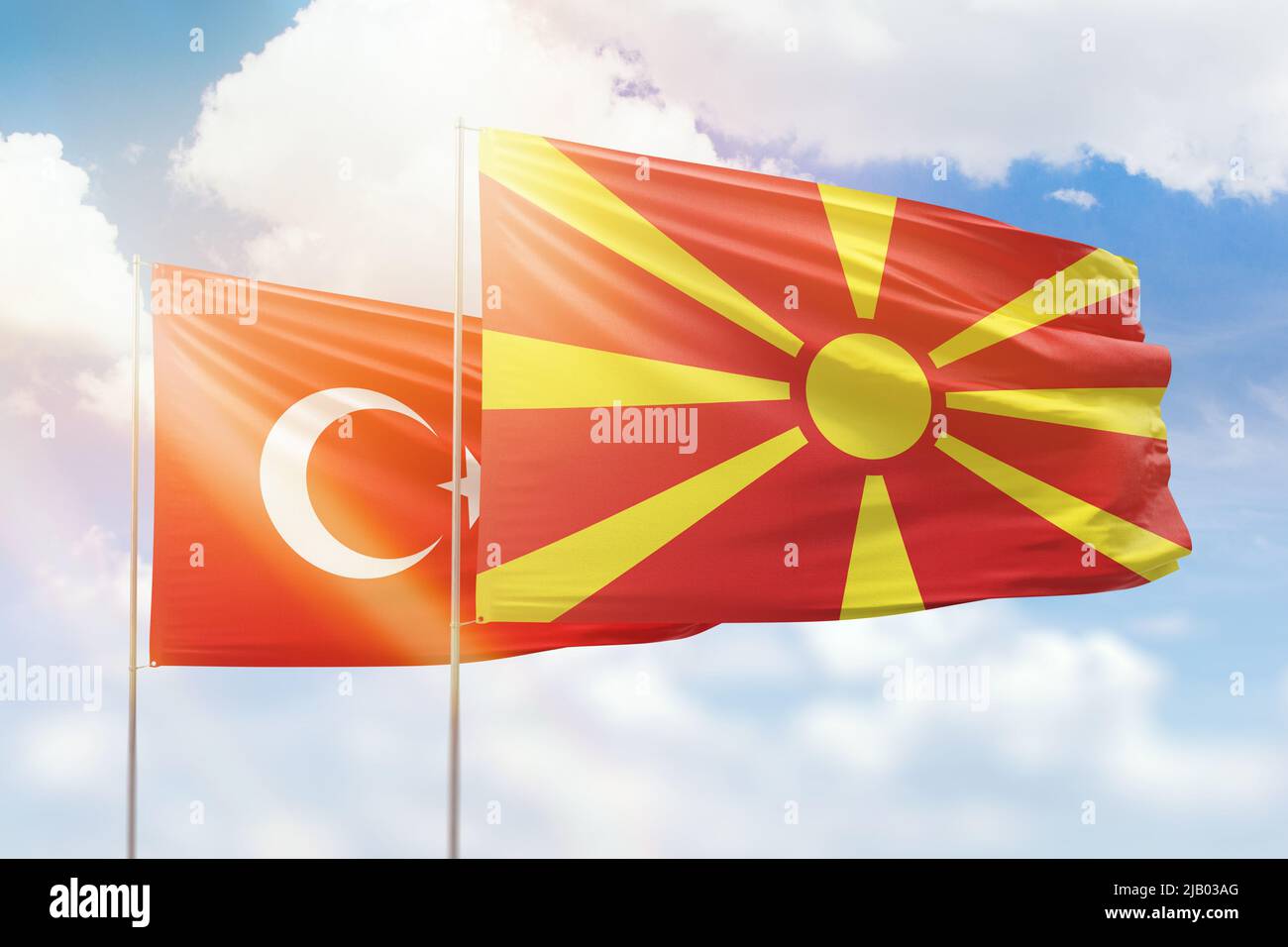 Sunny blue sky and flags of north macedonia and turkey Stock Photo