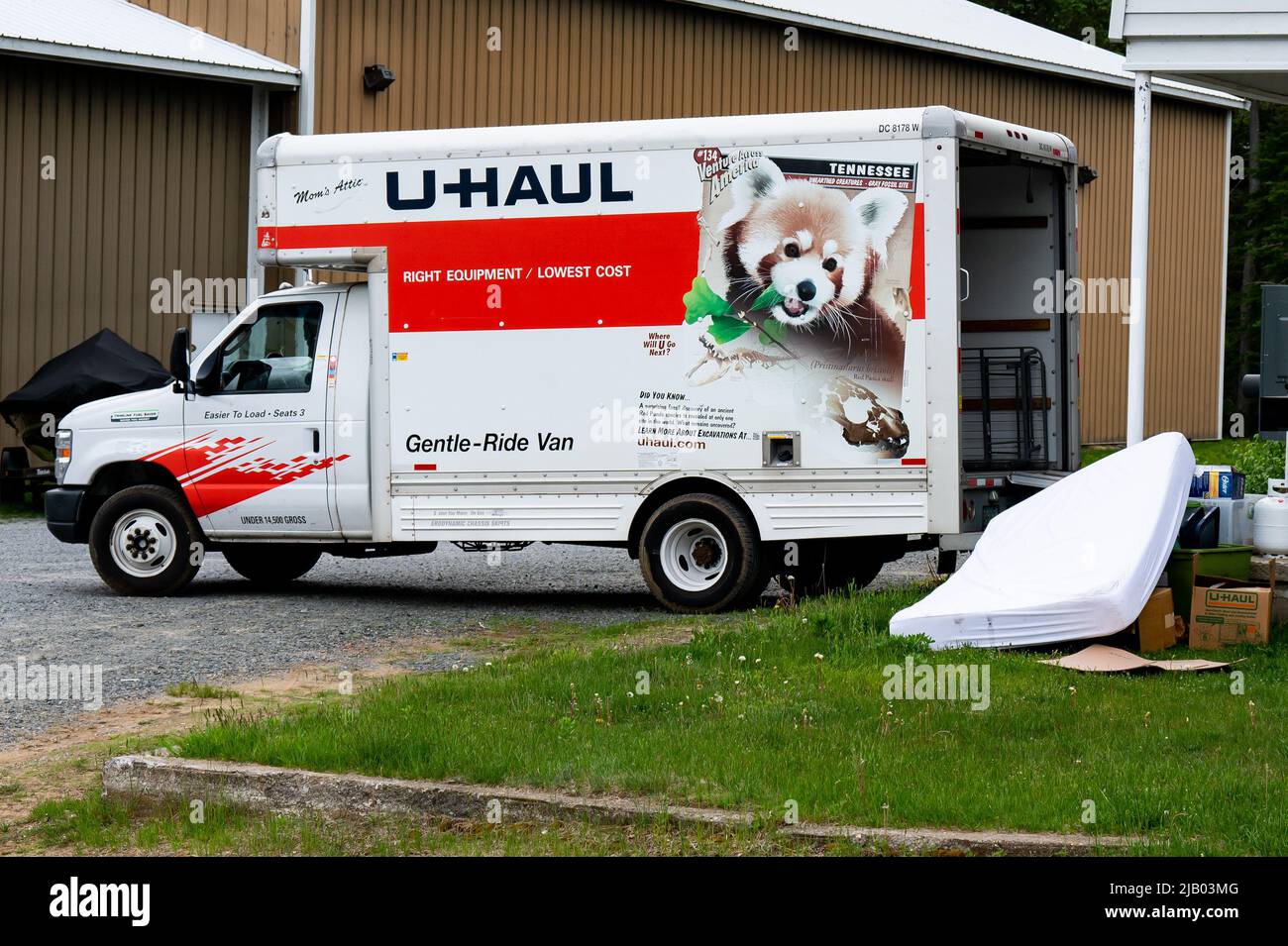 A U-Haul truck being loaded with household items by a person moving to a new residence Stock Photo