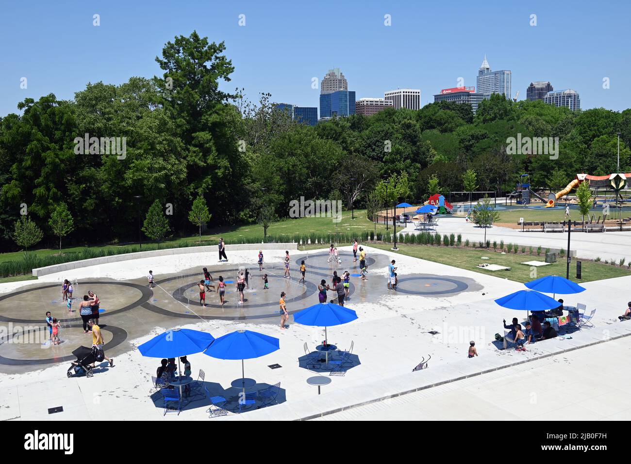 The splash pad at John Chavis Memorial Park with the downtown Raleigh