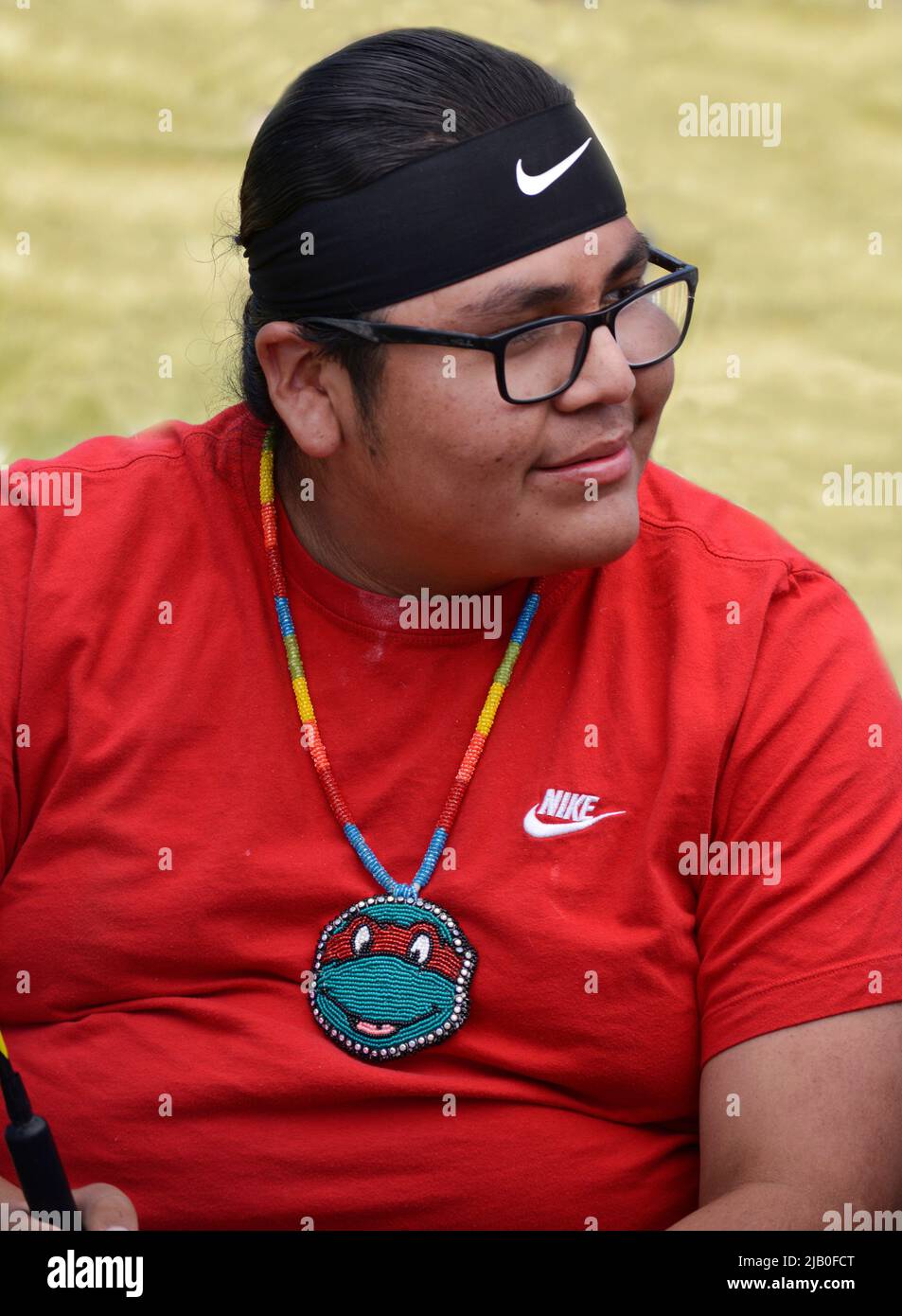 A Native American drummer wearing a handmade beaded Teenage Mutant Ninja Turtle pendant performs at a pow wow in Santa Fe, New Mexico. Stock Photo