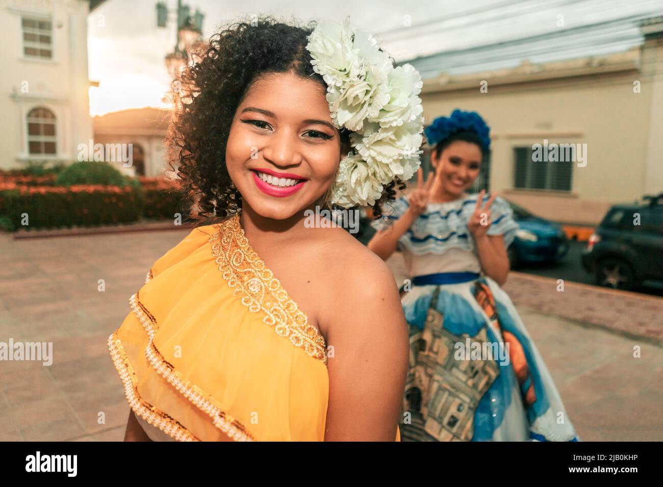 Two traditional dancers with the typical Nicaraguan costume having fun, goofing around and fooling around during sunset on a street in Leon Nicaragua Stock Photo