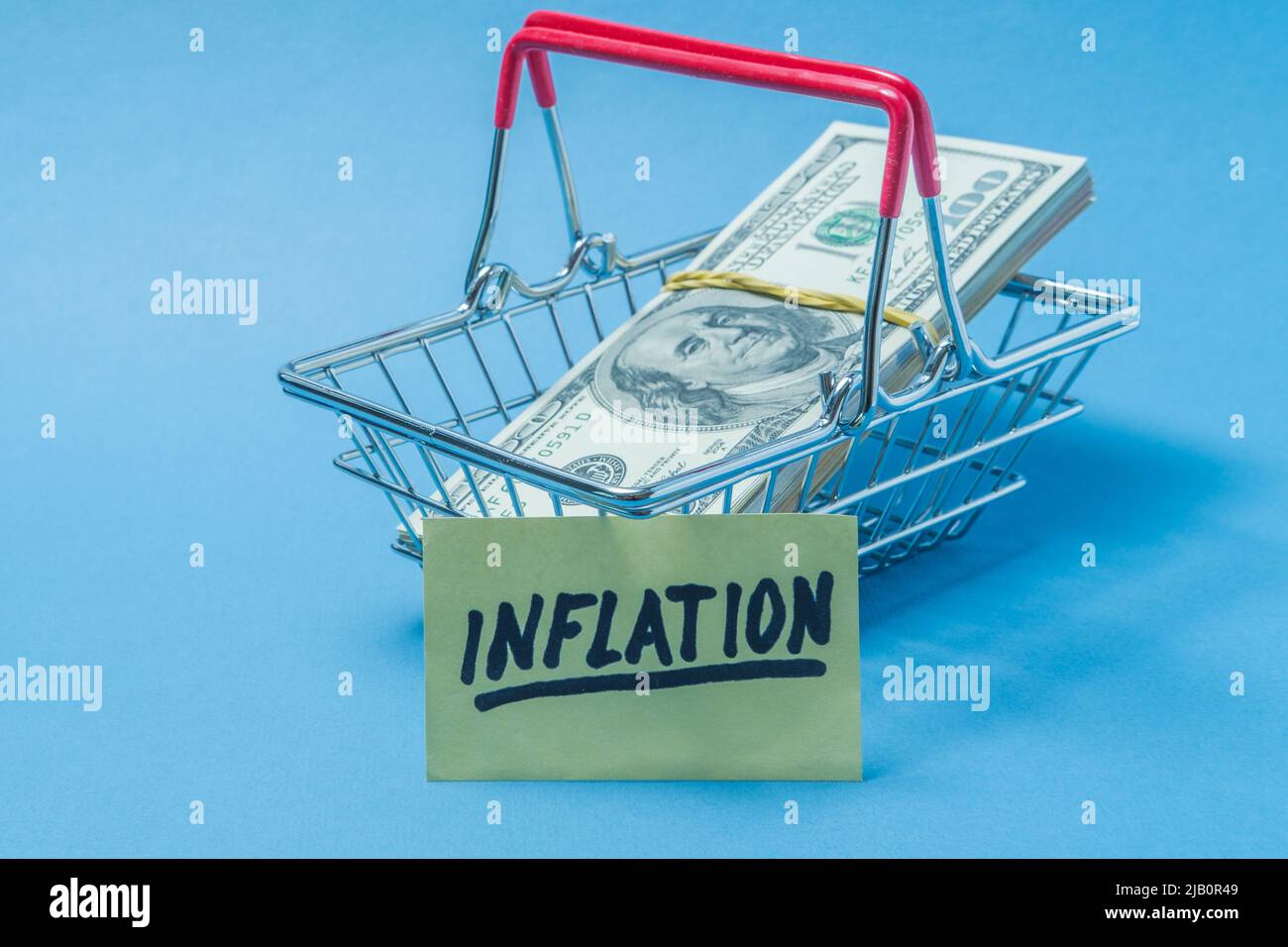 Dollars are in a grocery basket, with a poster on which the inscription inflation Stock Photo