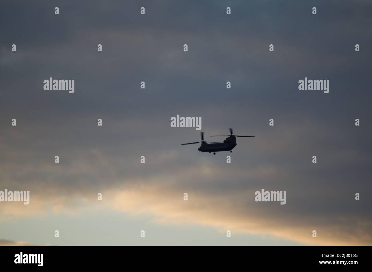 Silhouette of a CH47 Chinook Helicopter over the Windsor/Detroit sky. Military Cargo Helicopter. Stock Photo