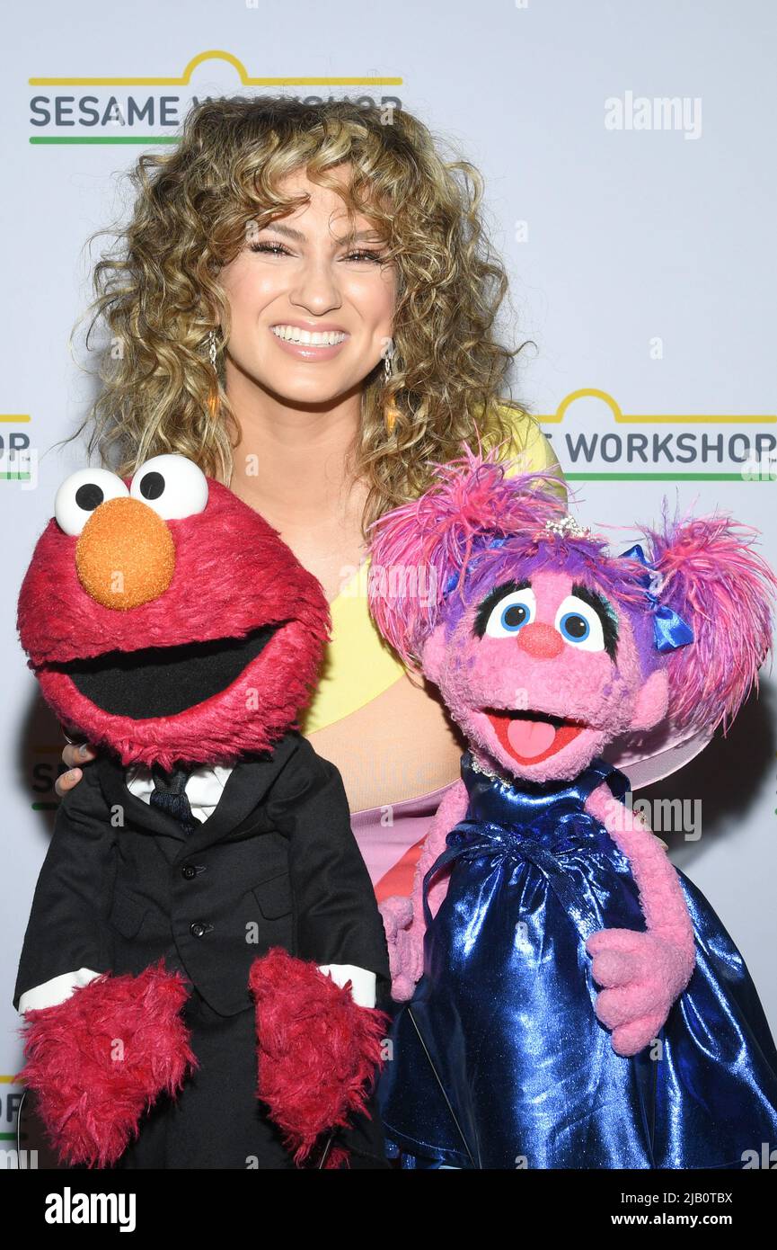 Tori Kelly poses with Sesame Street characters Elmo and Abby Cadabby during  the 2022 Sesame Workshop