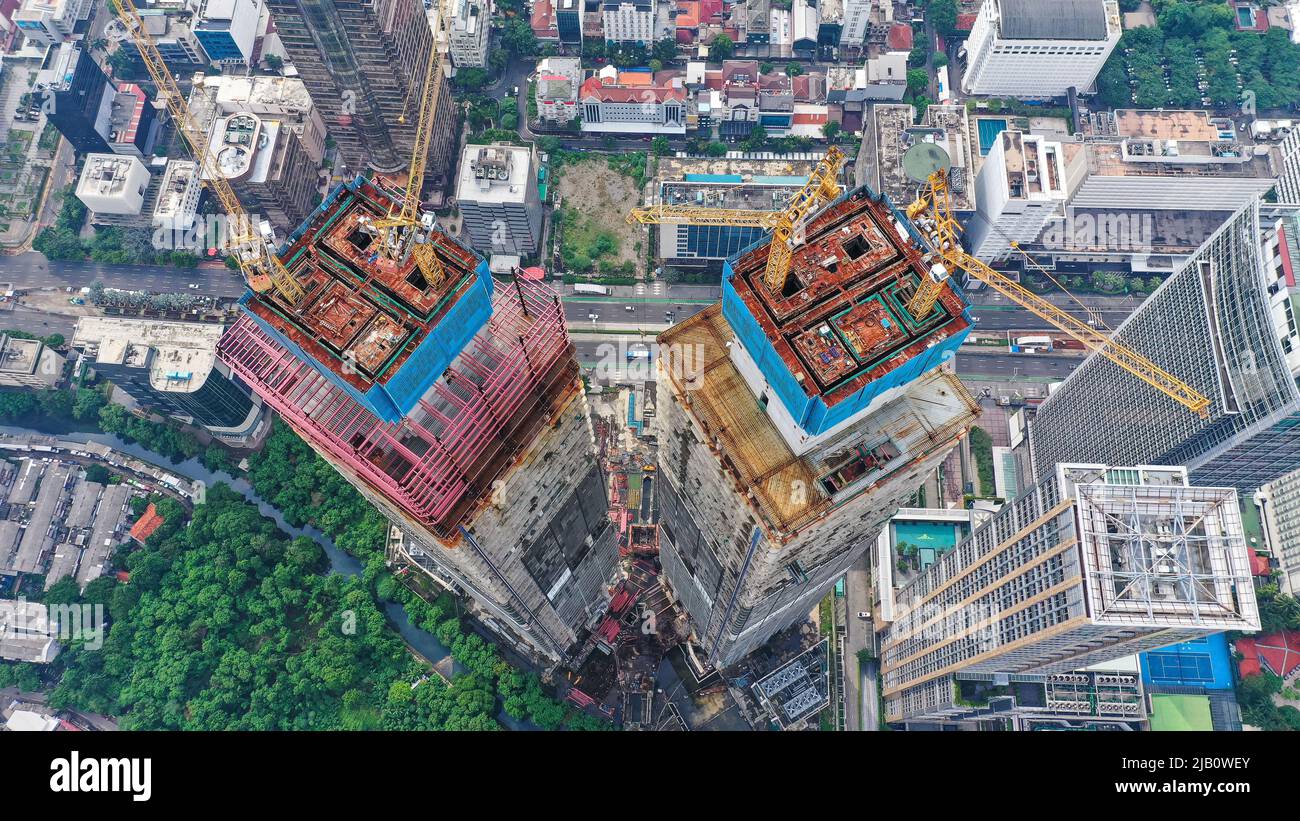 Skyscraper under construction in Jakarta city. Top down cranes on the