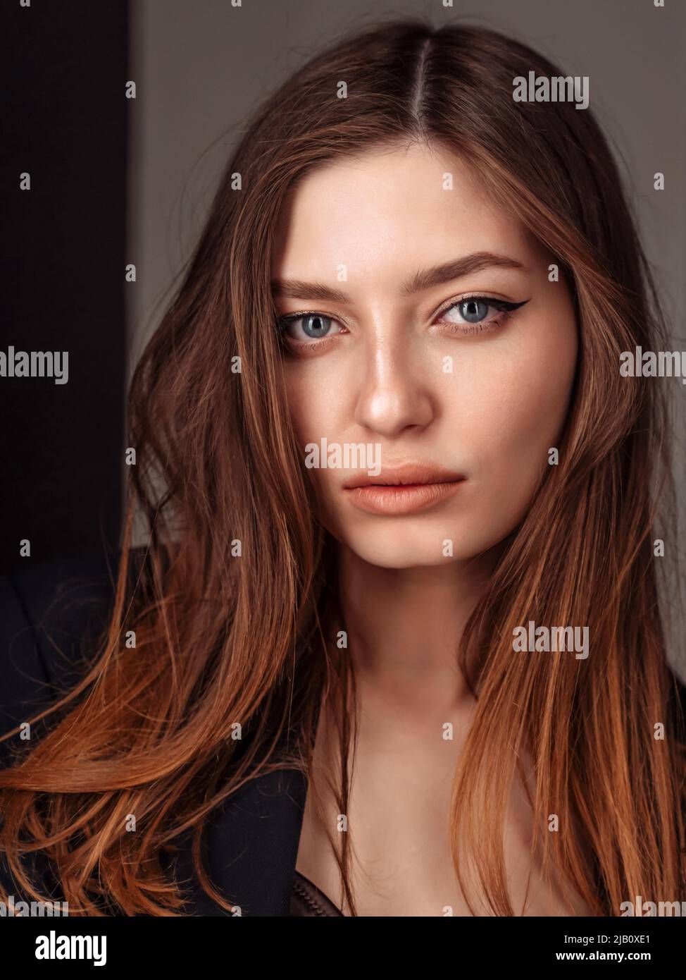 Close up portrait of joyless 20-25s woman standing alone. Face serious female with sad eyes staring at camera. vertical Stock Photo