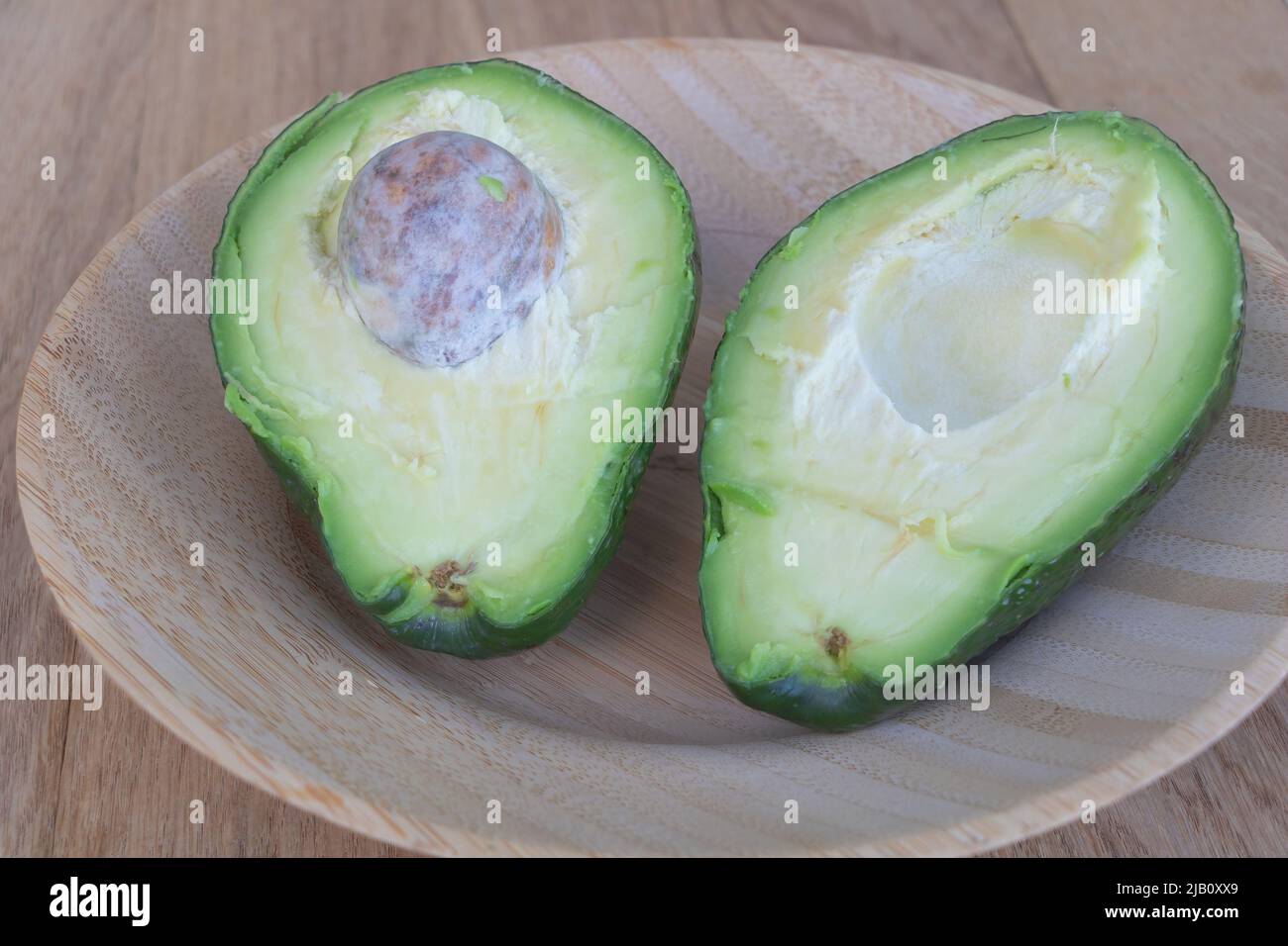 Close up shot an avocado cut in half on a wooden plate Benefits of