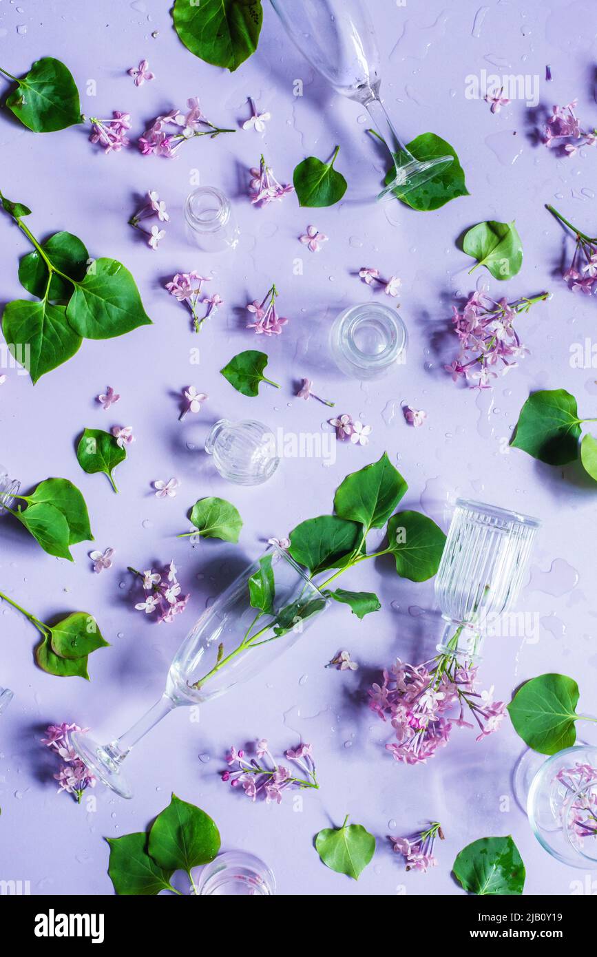 Glass bottles with lilac flowers, pastel colors flat lay, violet still life from above Stock Photo